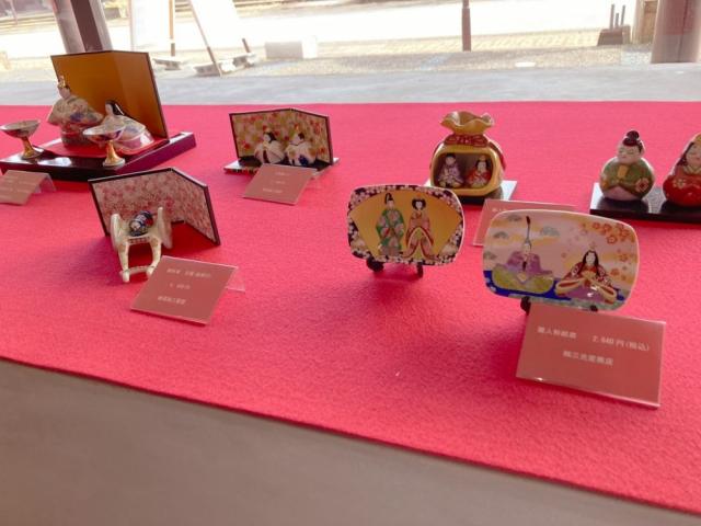 写真：卓上用の雛人形が5組、雛人形の絵が描かれたお皿が2枚展示されている様子