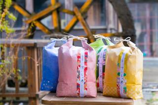 写真：ピンク、黄色、青などのカラフルな米袋