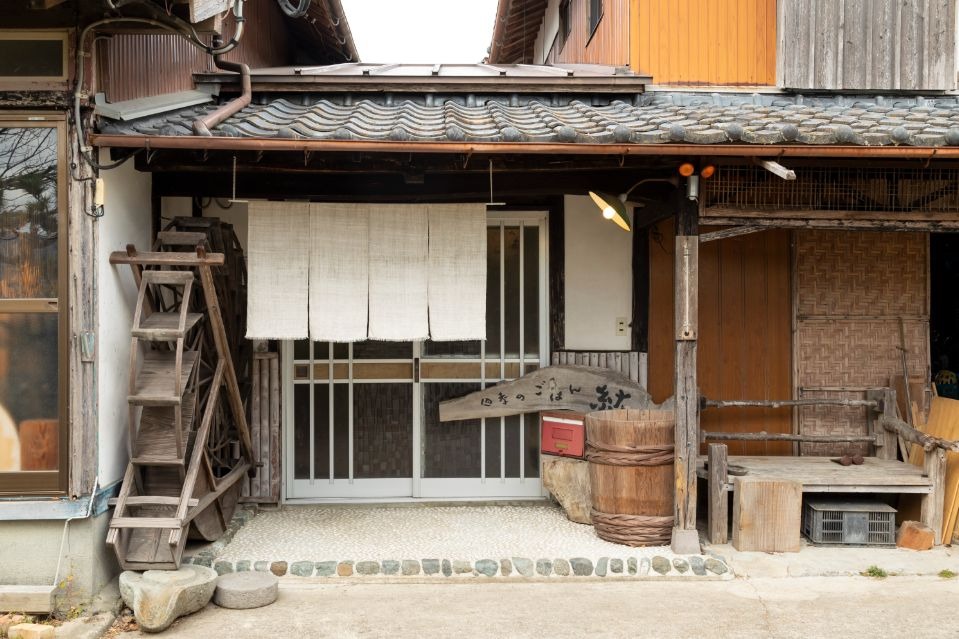 日本家屋の玄関に白い暖簾が掛かった店舗外観画像