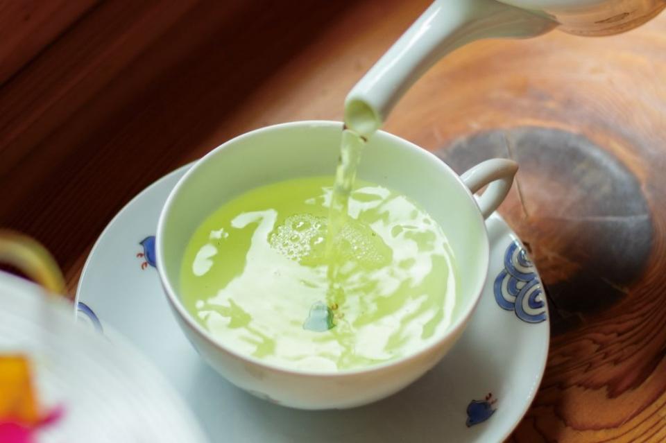 写真：ティーカップに緑茶を注いでいる様子