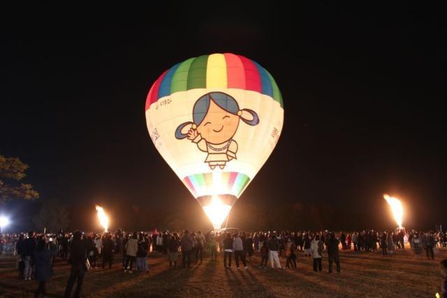 写真：冬の夜に暖かなバーナーの炎が光を放つ熱気球「ひみか号」の夜間係留