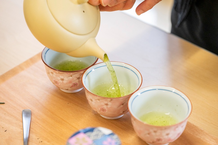 写真：3つの茶碗に急須からお茶を注いている様子
