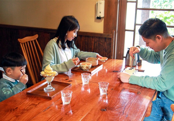 写真：テーブル席で食事する家族その1