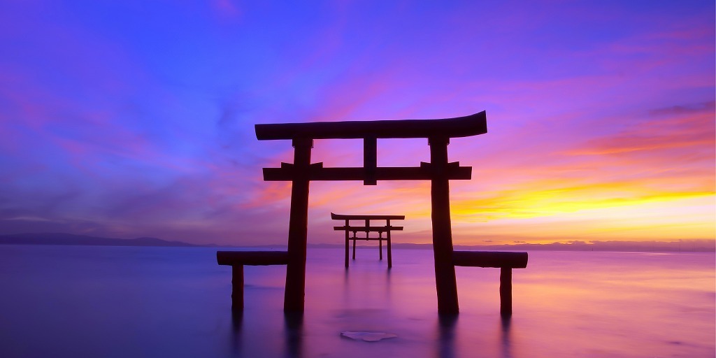 写真：夕暮れの海に建つ鳥居の画像