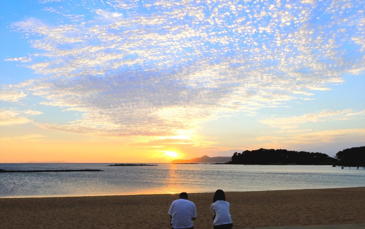 写真：砂浜と夕日の風景