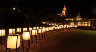 写真：夜景の中、通路沿いに灯篭が並べられた様子