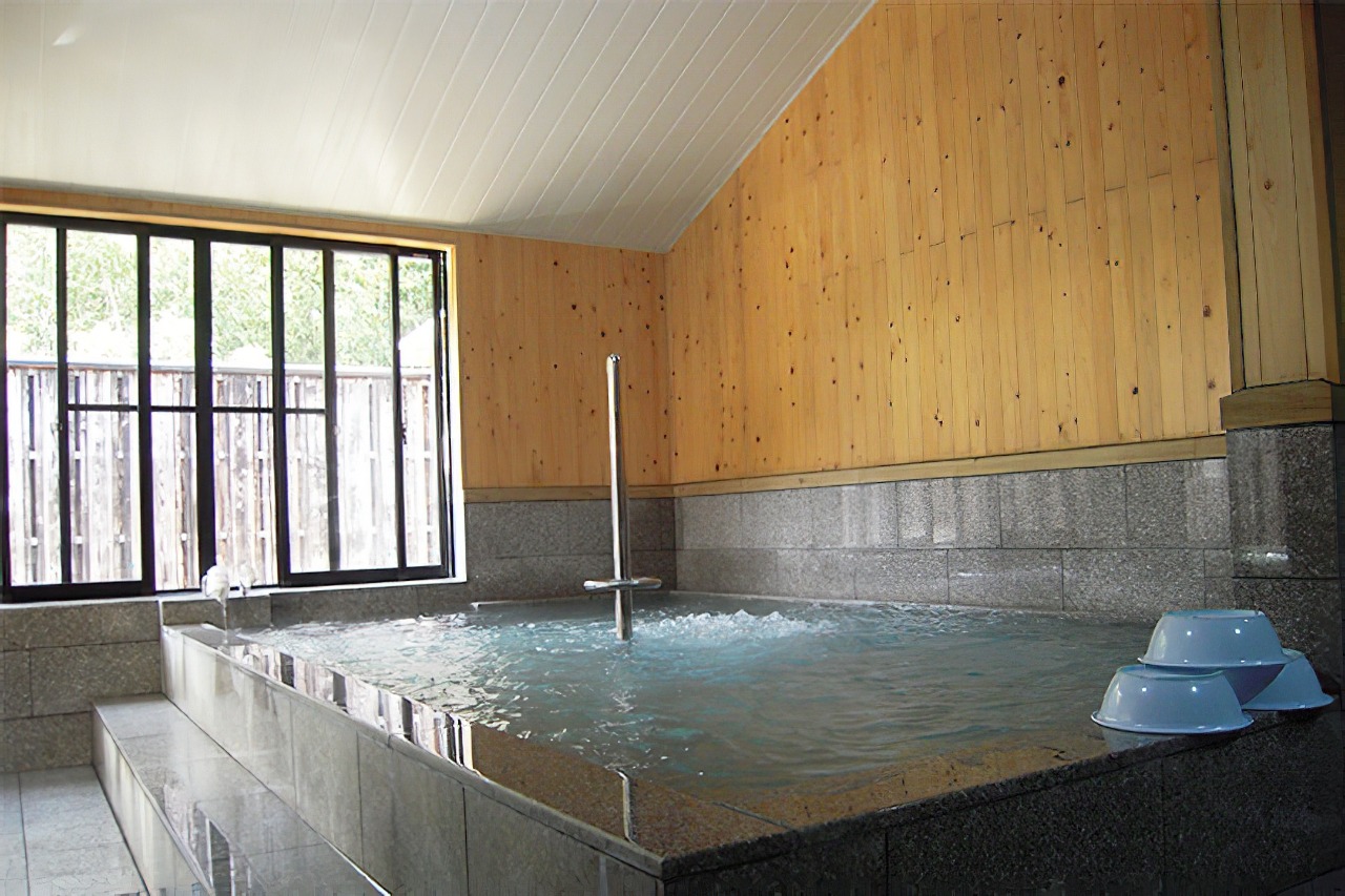写真：板張りの室内にある石造りの浴場
