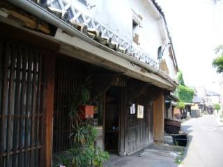 写真：木造の玄関と2階の壁が白壁の昔の日本家屋