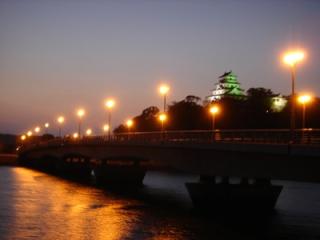 写真：黄昏時の舞鶴橋と奥にそびえる唐津城天守閣の風景