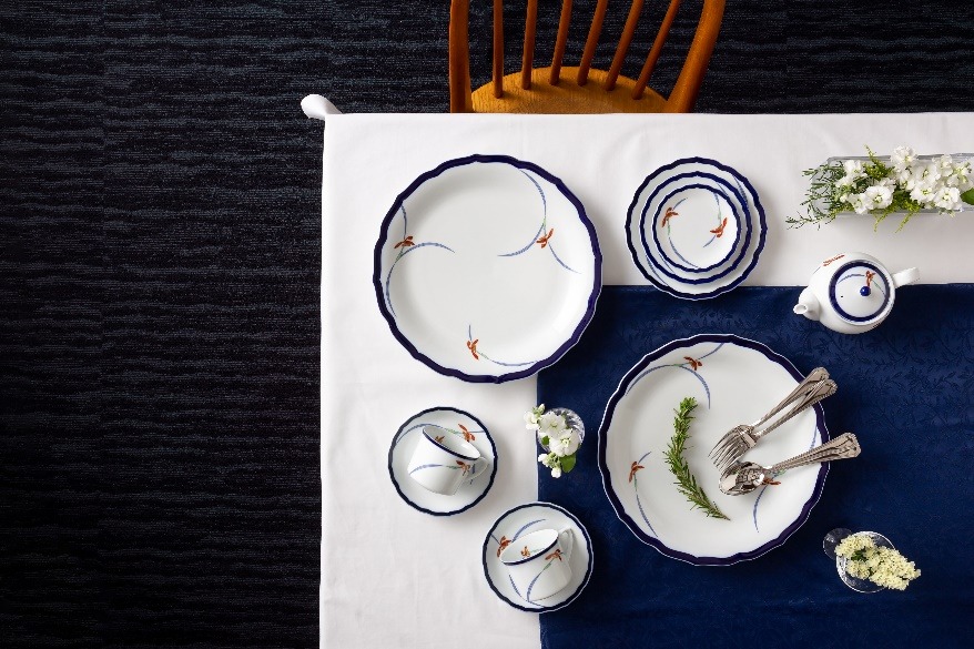 写真：長い間絶大な人気を誇る香蘭社の代表的なオーキッドレースのシリーズ。ルリボーダーが美しく、上品な蘭のデザインで、お料理が映えます。