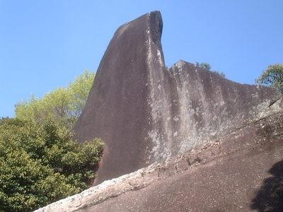 写真：山の中にそびえる烏帽子型の巨大な岩