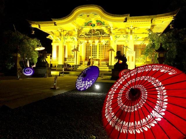 写真：ライトアップされた本殿の前に番傘が飾られている
