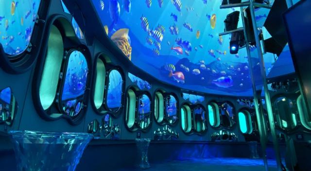 写真：玄海海中展望塔の内部。天井に海を泳ぐ魚のプロジェクションマッピングが施されている様子