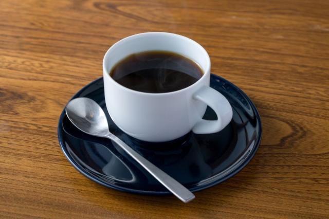 青い受け皿と白いカップにコーヒーが入った画像