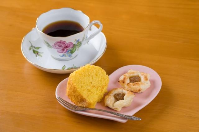 ハート形の皿にケーキとクッキーが盛られ、左上にコーヒーが添えられた画像