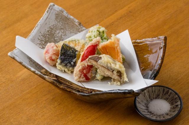 様々な野菜の天ぷらと塩が添えられた画像