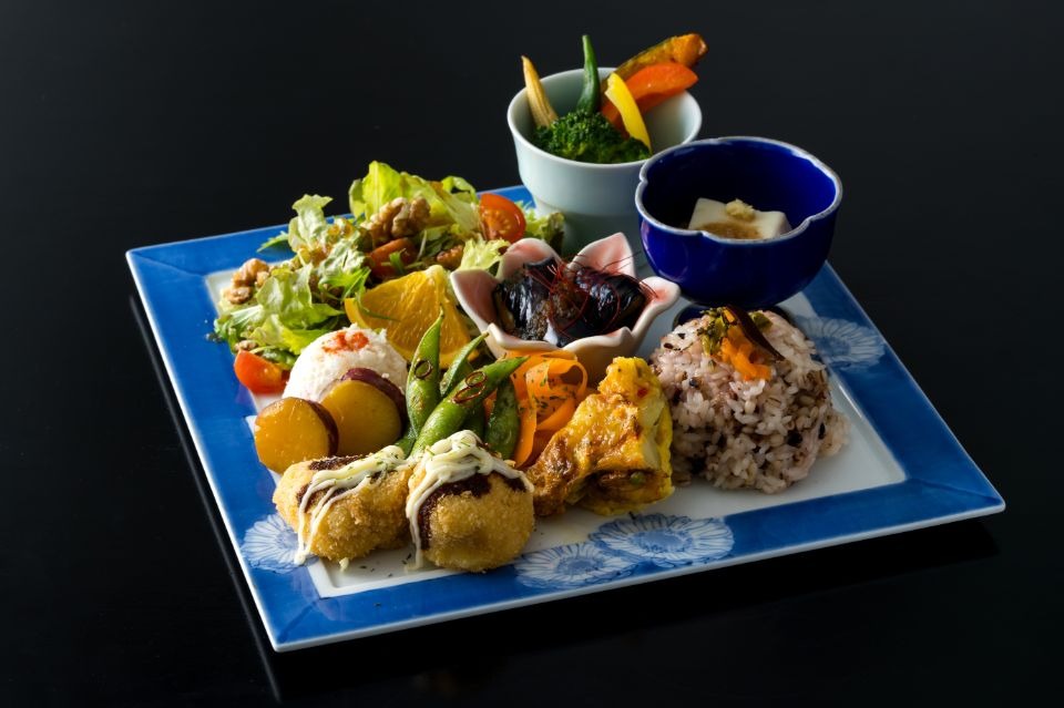 青く四角の皿に呉豆腐コロッケと野菜がふんだんに使用された料理画像