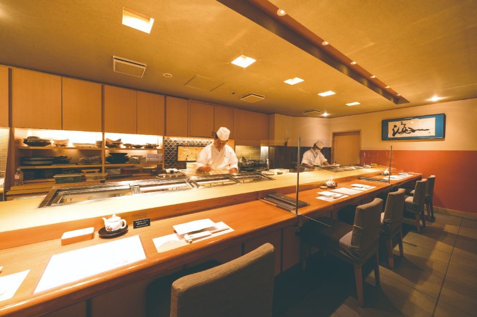 真ん中に職人が寿司を握っている、寿司屋のカウンター画像